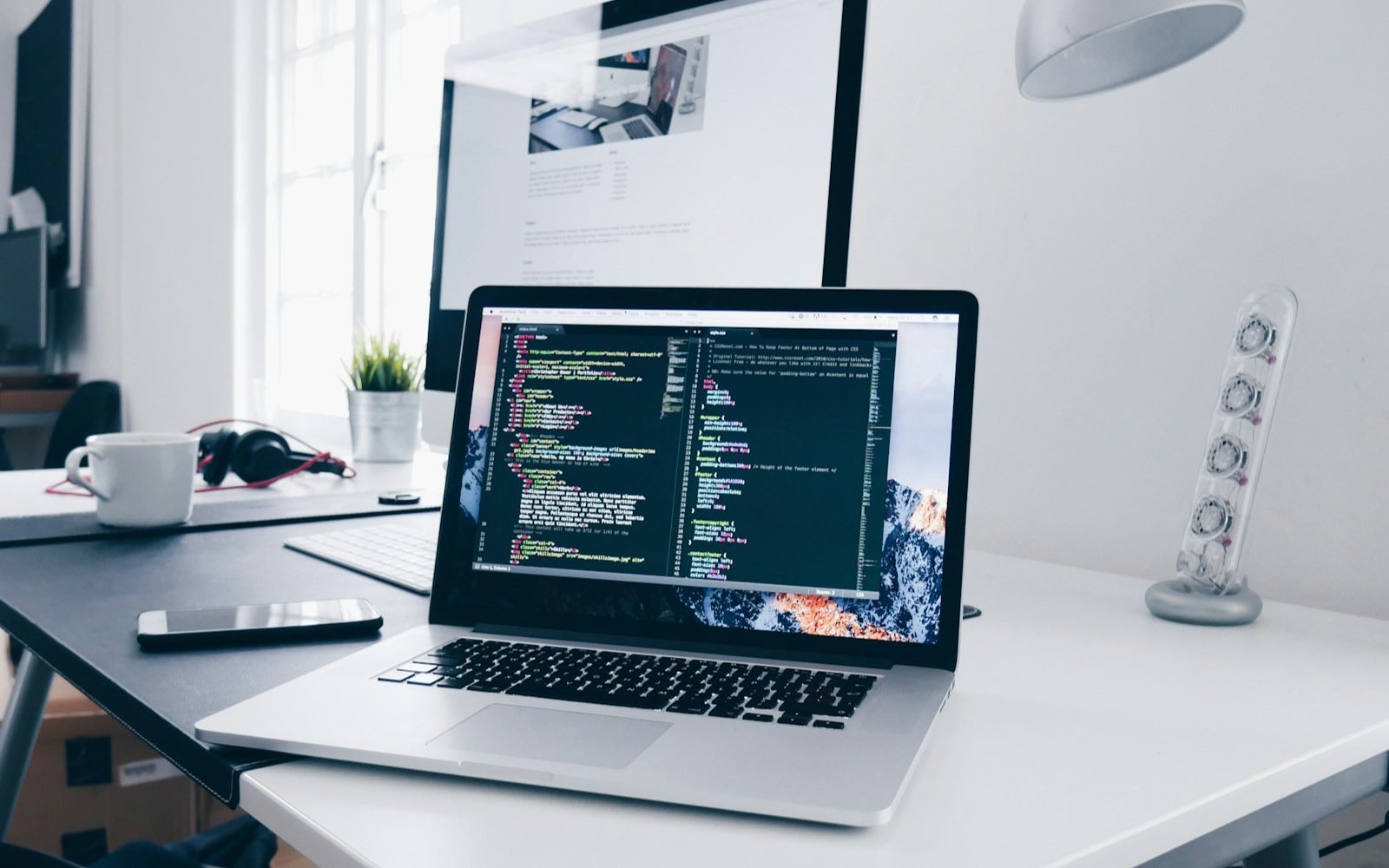Laptop mostrando líneas de código sobre un escritorio de trabajo. Foto: Christopher Gower, Unsplash