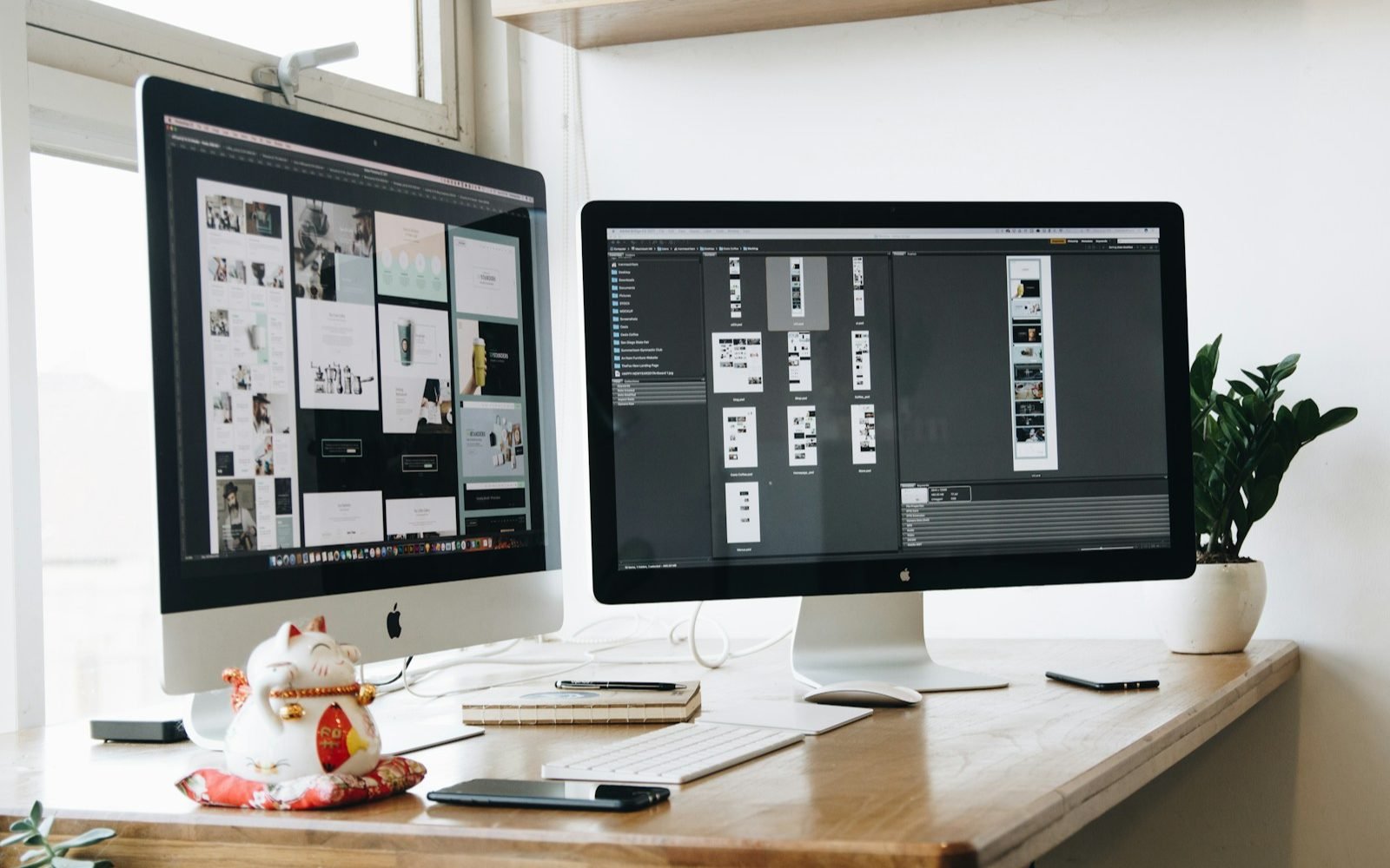 Escritorio con dos monitores mostrando bocetos de diseño de sitios web
