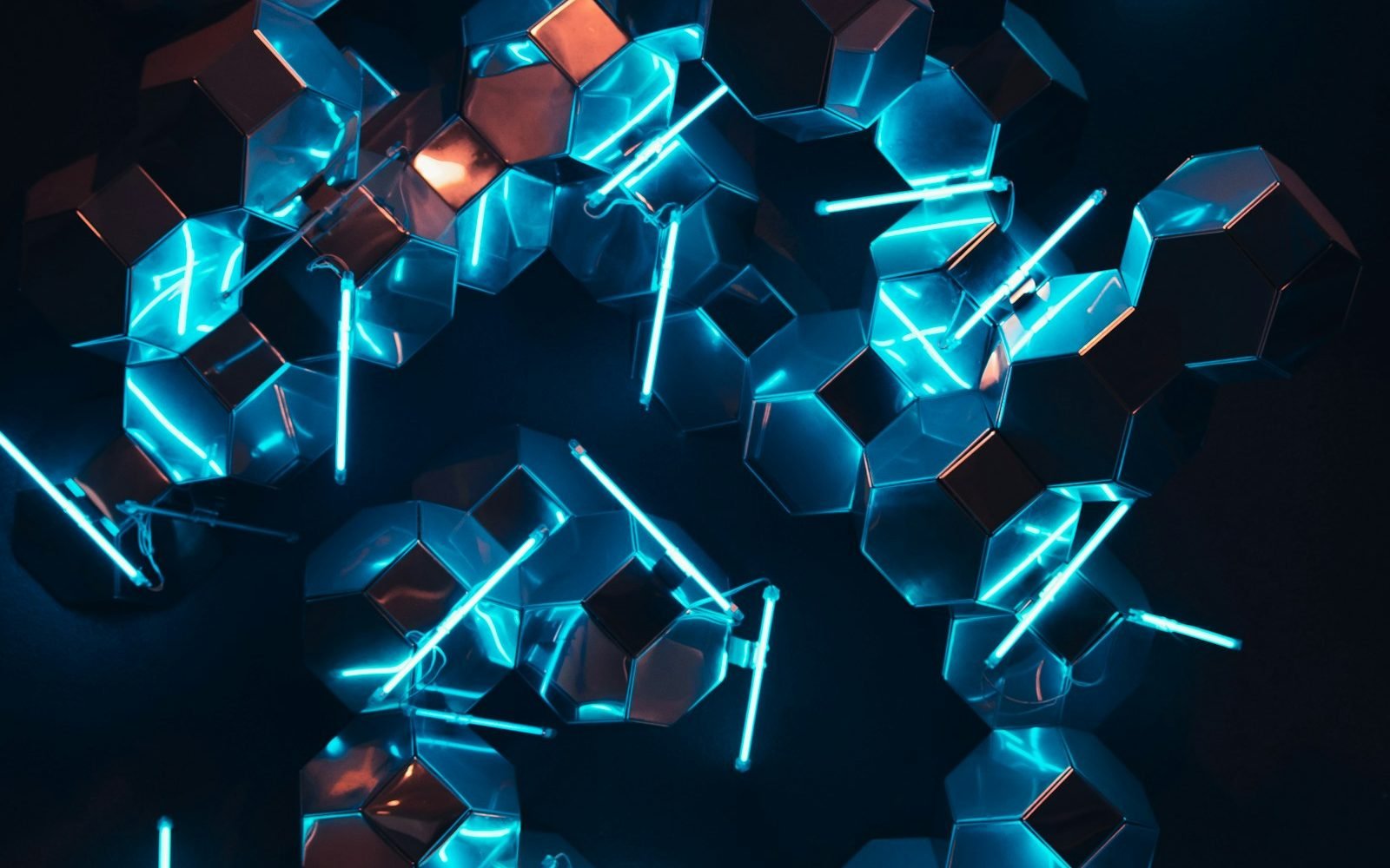 Cristales geométricos con luz turquesa sobre fondo oscuro