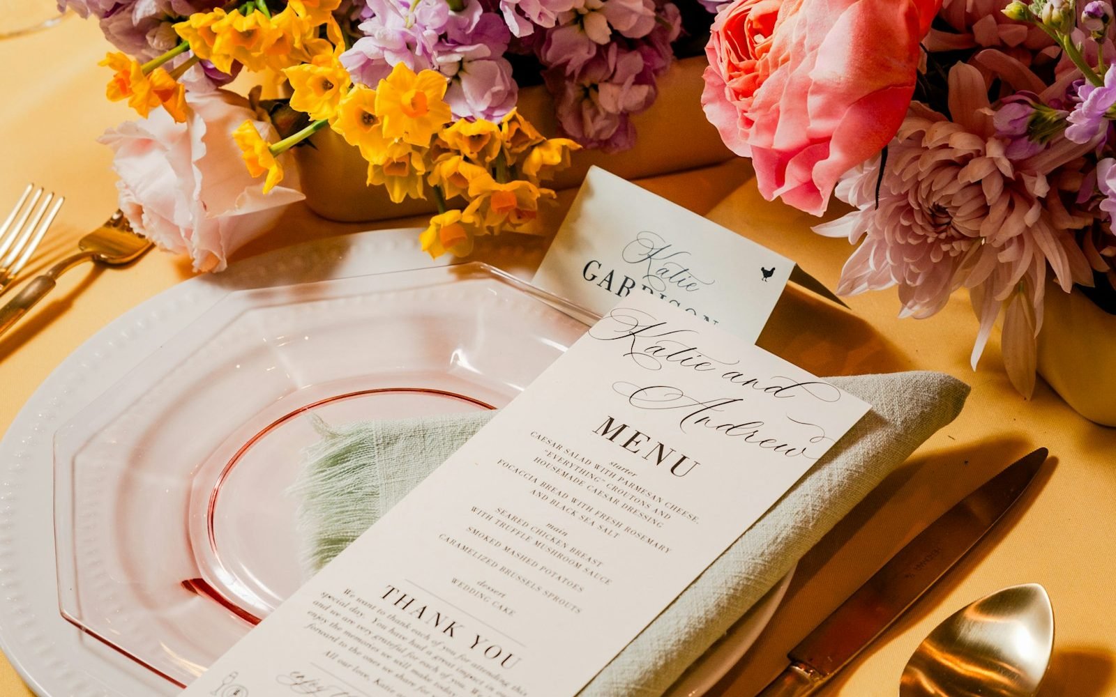 Menú impreso de boda sobre un plato junto a un arreglo de flores. Foto: Kari Bjorn Photography, Unsplash