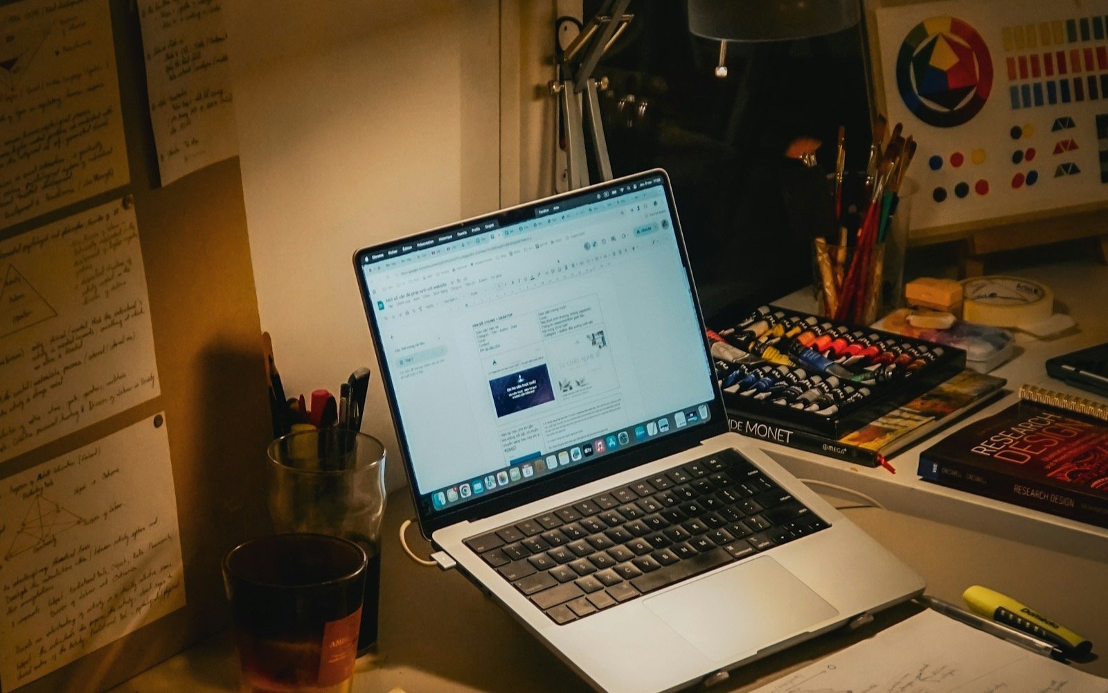 Escritorio con laptop, libros y papeles por la noche. Foto: Yen Vu, Unsplash