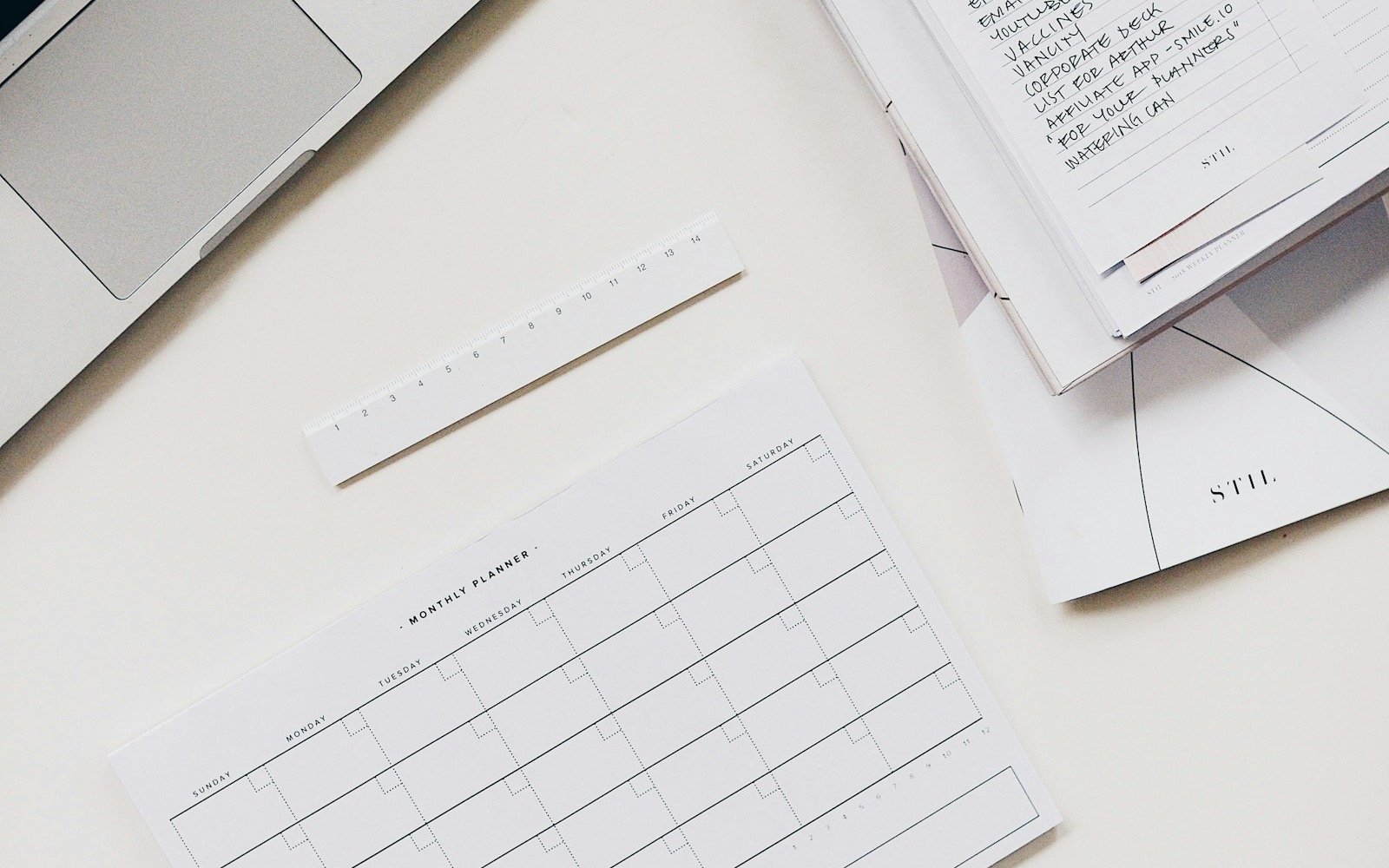 Calendario mensual en blanco y una laptop sobre una mesa clara. Foto: Marissa Grootes, Unsplash
