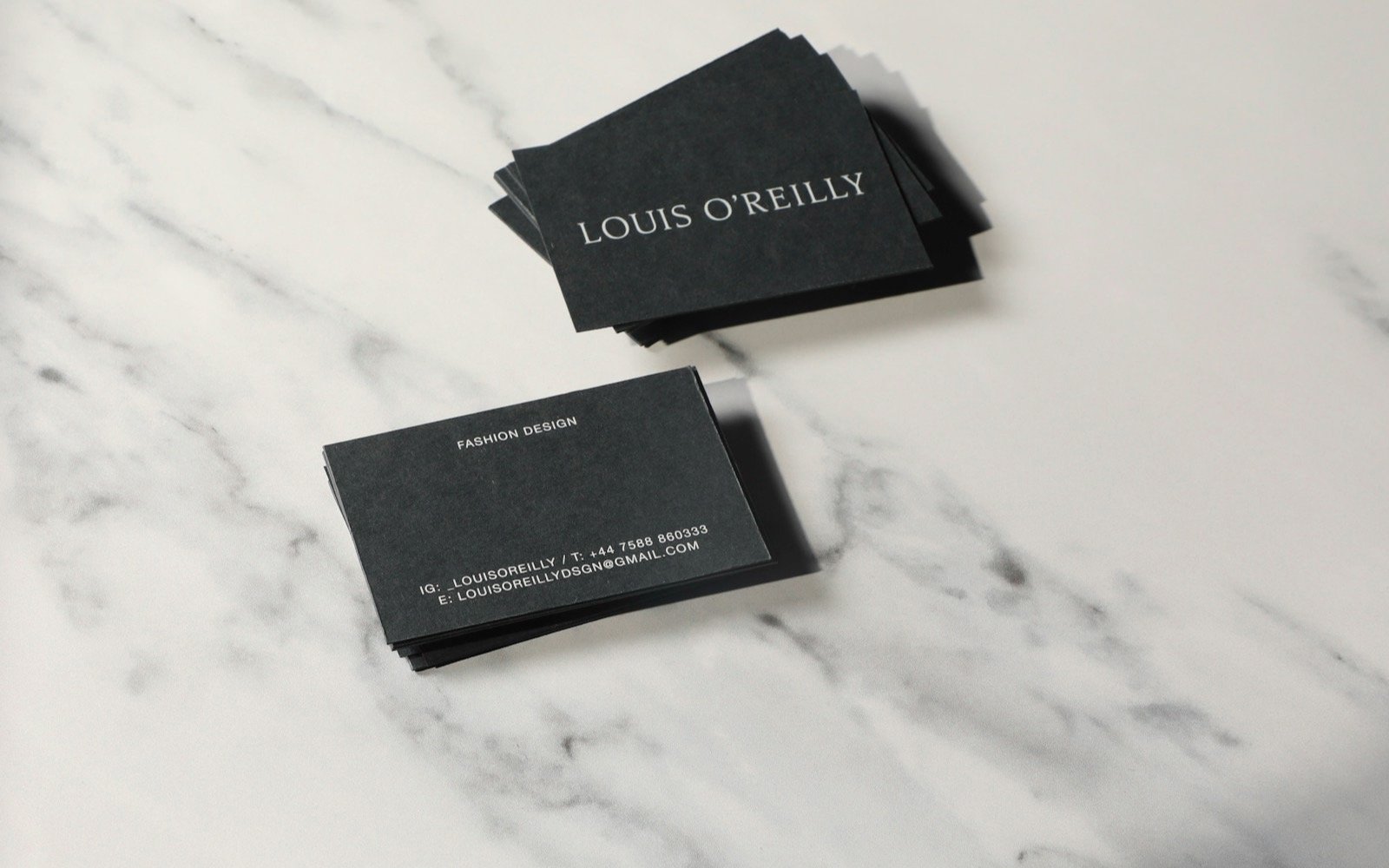 Dos tarjetas de presentación sobre una superficie de mármol. Foto: Julian Tong, Unsplash